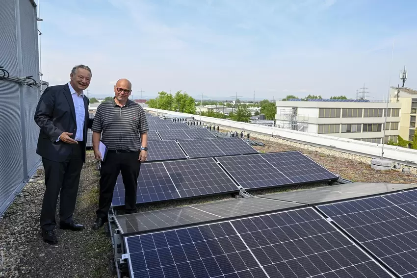 Langefeld und Bereichsleiter Horst Schröder inmitten der Fotovoltaikanlage auf dem Dach.