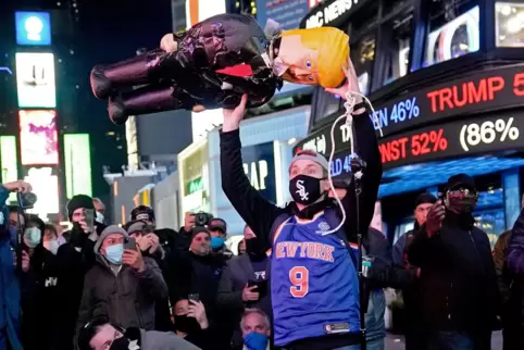 Am New Yorker Times Square hält ein Demonstrant eine Trump-Puppe hoch. 