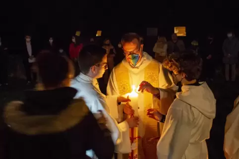 Licht ins Dunkel der Kirche gebracht: Diözesanjugendseelsorger Andreas Rubel entzündet gemeinsam mit den Jugendlichen die Osterk