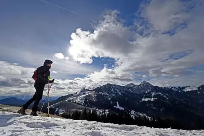 Ein Mann wandert in einer Berglandschaft mit Schnee