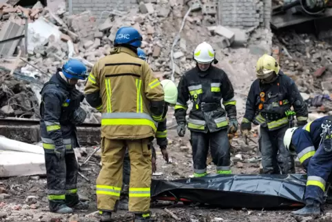 Rettungskräfte bergen zwischen Trümmern eine Leiche. Die Behörden in Saporischschja im Süden der Ukraine meldeten am 11. Novembe