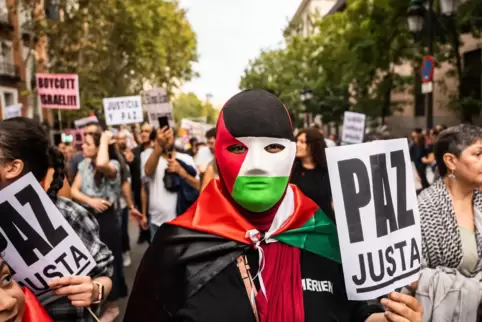  Madrid, Mitte Oktober: Ein Mann trägt eine Maske mit den Farben der palästinensischen Flagge während einer Demonstration. 