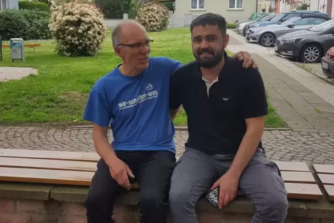 Besondere Freundschaft: Pfarrer Andreas Buchholz und Hishyar Hussain auf der Bank vor der Waldseer Kirche, die Hussain lackiert 