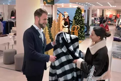 Kaufhof: Geschäftsführer Niko Rauch zeigt einer Kundin einen Mantel.