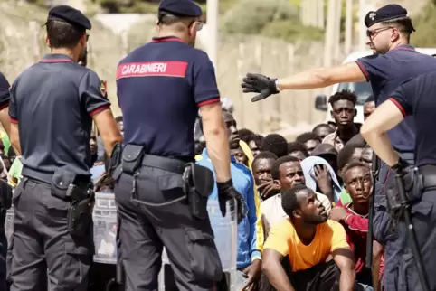 Europa setzt stärker auf Abschottung: Italienische Carabinieri sprechen mit Migranten in einem Aufnahmezentrum auf der Insel Lam