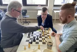 Gerhard Landeck (links) und Fabian Mäurer (rechts) spielen ihre Partie aus der dritten Runde nach, Arkadi Syrov schaut zu. 