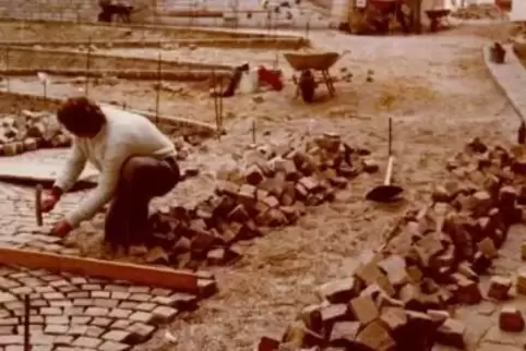 Historische Aufnahmen: Arbeiter bei Pflaster- und Brunnenarbeiten in der Fußgängerzone. 