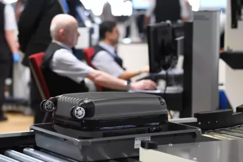Der Koffer eines Flugreisenden läuft im Terminal 1 des Frankfurter Flughafens an der Passagierkontrolle zu einem Gepäck-Scanner.