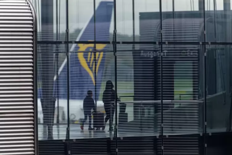 Passagiere vor dem Leitwerk einer Ryanair Maschine