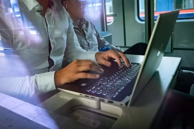 Pendler arbeiten am Laptop im Zug