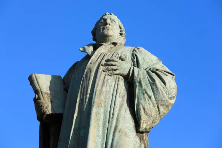 Luther-Denkmal vor der Johanniskirche in Magdeburg vor blauem Himmel, Aufnahme von schräg unten