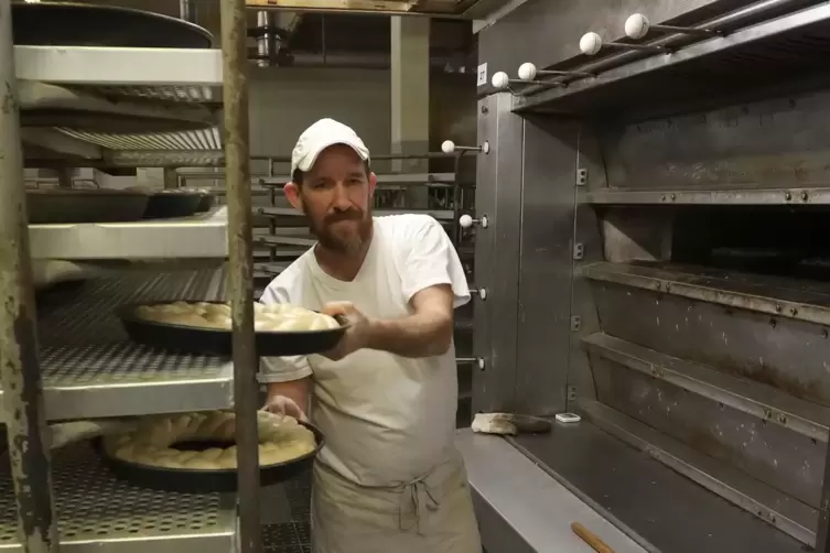 Thomas Hoeltzel schiebt die Backformen in den 200 Grad hei&szlig;en Ofen. 