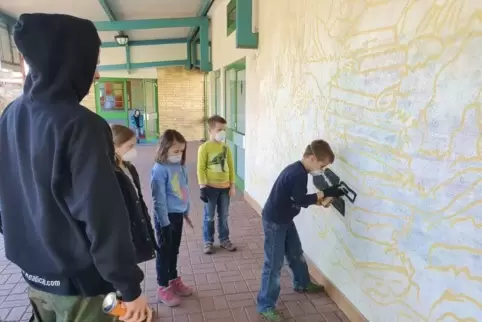 Künstler Carl Kenz (links) hat die Konturen des Bildes an die Wand der Grundschule in Höheinöd gemalt. Jetzt werden die Flächen 