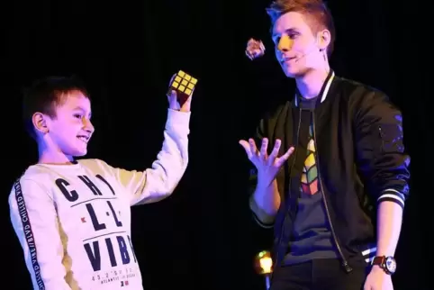Magier Marco Weissenberg (rechts) zaubert mit Zuschauer David. 