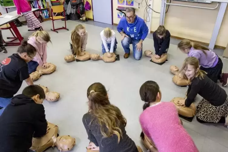 Reanimationstraining in der 4a: Die Grundschüler üben unter der Anleitung von Arzt Sebastian Henn an Puppen.