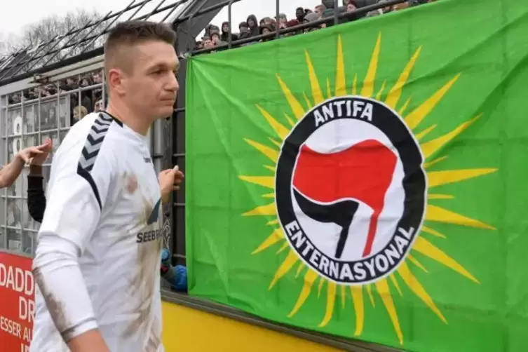 Auf der Außenbahn: Daniel Frahn vor der Fankurve des SV Babelsberg, dessen Anhänger den Zaun mit einer Antifa-Fahne geschmückt h