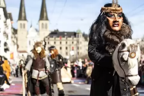 Maskierte Karnevalsteilnehmer ziehen am Wochenende durch die Straßen.