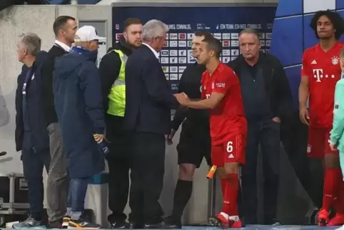 Hoffenheim-Mäzen Dietmar Hopp und Bayern-Spieler Thiago geben sich während einer Spielunterbrechung die Hand. 