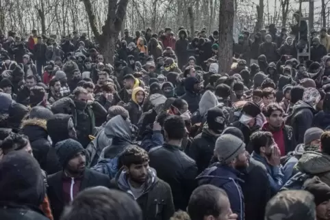 Migranten warten nach ihrer Ankunft am türkisch-griechischen Grenzübergang bei Pazarkule. 