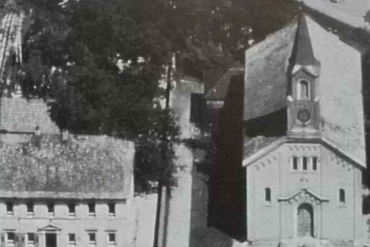 Auf einem alten Foto: das Schulgeb&auml;ude neben der Kirche. 1970 wurde der Bau abgerissen.