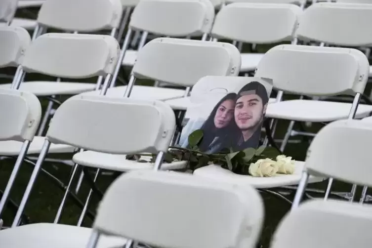 Ein Bild von zwei Opfern des Flugzeugunglücks auf einem von 298 Stühlen, die Angehörige der 298 Opfer in der Nähe der russischen