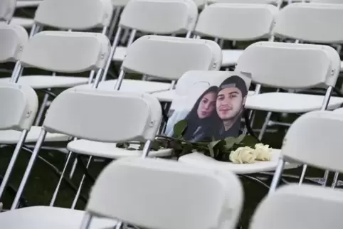 Ein Bild von zwei Opfern des Flugzeugunglücks auf einem von 298 Stühlen, die Angehörige der 298 Opfer in der Nähe der russischen
