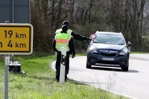 Kurz hinter der Grenze kontrollieren Mitarbeiter der Bundespolizei bei Schweigen Fahrzeuge an der Weinstraße.
