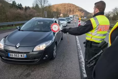 Beamte der Bundespolizei halten ein Auto an, das aus Frankreich nach Deutschland einreist. Französische Staatsbürger dürfen nur 