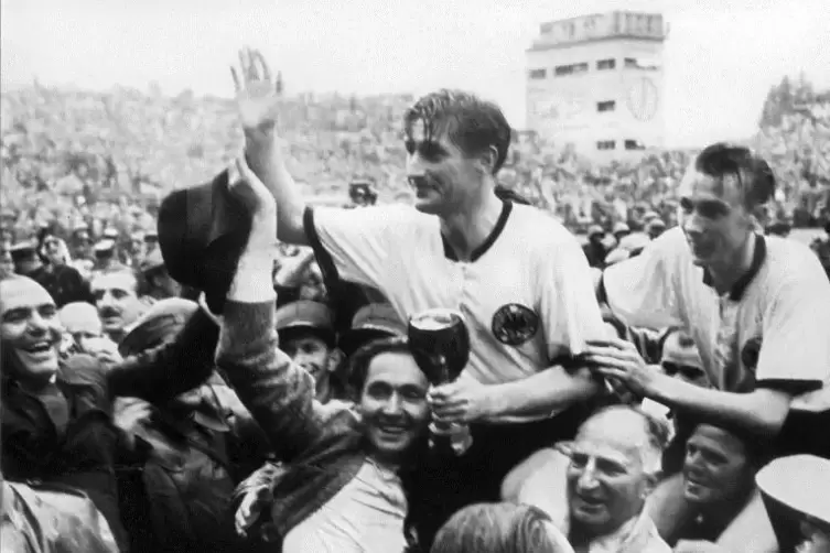 WM 1954: Fritz Walter winkt und h&auml;lt den Jules-Rimet-Pokal in der Hand. Rechts: Horst Eckel. 