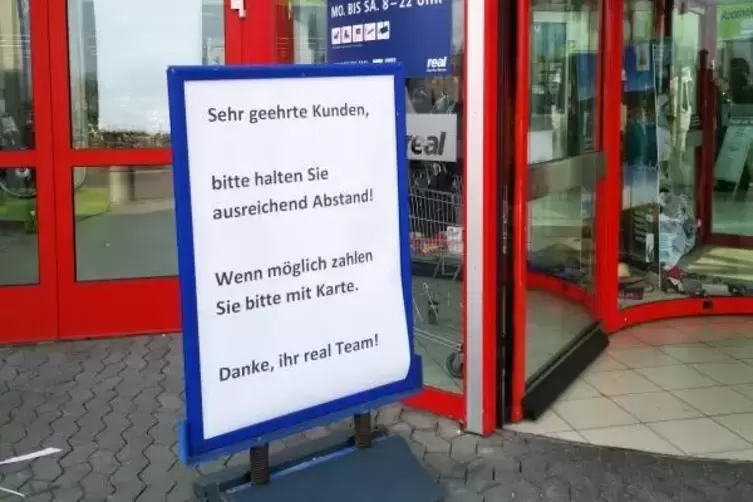 Bitte Abstand halten und mit Karte zahlen - darum bittet der Real-Markt. 