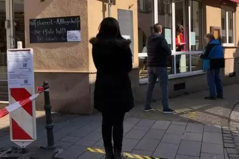 Die Gutscheine werden durch das Fenster des „Hilfsbereit“-Büros verteilt.