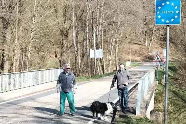 Roland Kitto mit Hund Balu in Begleitung von Edwin Edrich (links) auf der Grenzbrücke am Brenschelbacher Bahnhof.