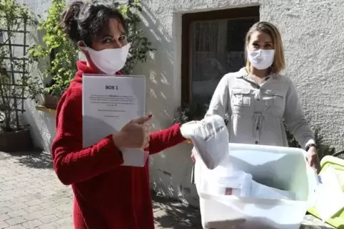Kyra und Anja Hohndorf sammeln abgegebene Masken ein.