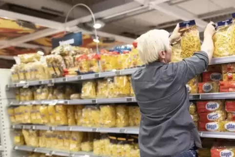 Eine Supermarkt-Mitarbeiterin am Nudelregal.