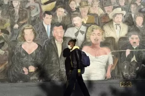 Ein Bild aus Los Angeles: Eine Frau geht an einem Wandgemälde mit Hollywood-Stars vorbei.