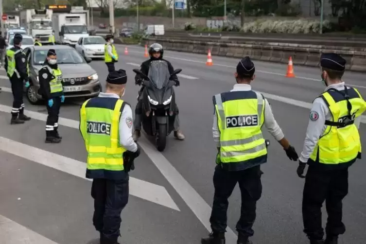 Französische Polizisten überprüfen die Fahrgenehmigungen von Verkehrsteilnehmern.