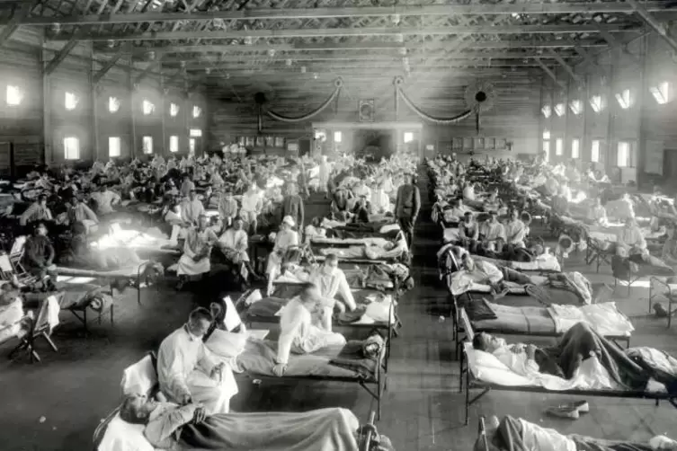Patienten, die an der Spanischen Grippe erkrankt sind, liegen in Betten eines Notfallkrankenhauses im Camp Funston in einer Mili