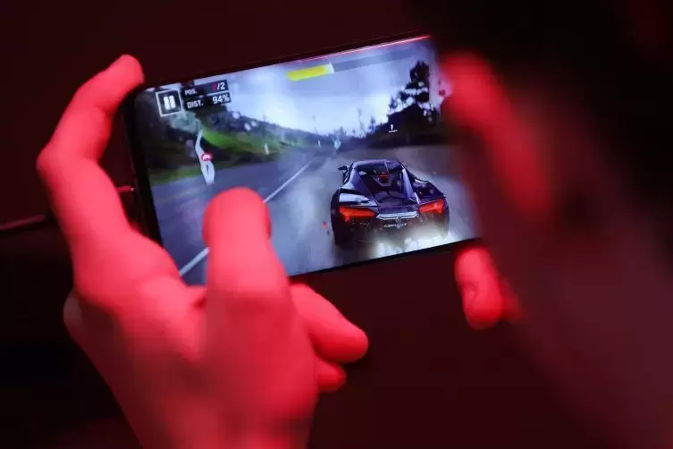 Ein Messebesucher testet auf der Gamescom 2019 ein Computerspiel auf einem Smartphone über das 5G Mobilfunknetz. 
