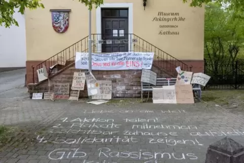 Aufgerüttelt durch die Morddrohung gegen Asomugha haben junge Frauen aus Trippstadt am Queidersbacher Rathaus eine stille Demons