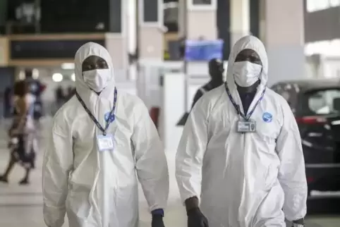 Luftfahrtarbeiter gehen wegen der Coronavirus-Pandemie in Schutzanzügen durch den Murtala Mohammed International Airport im nige