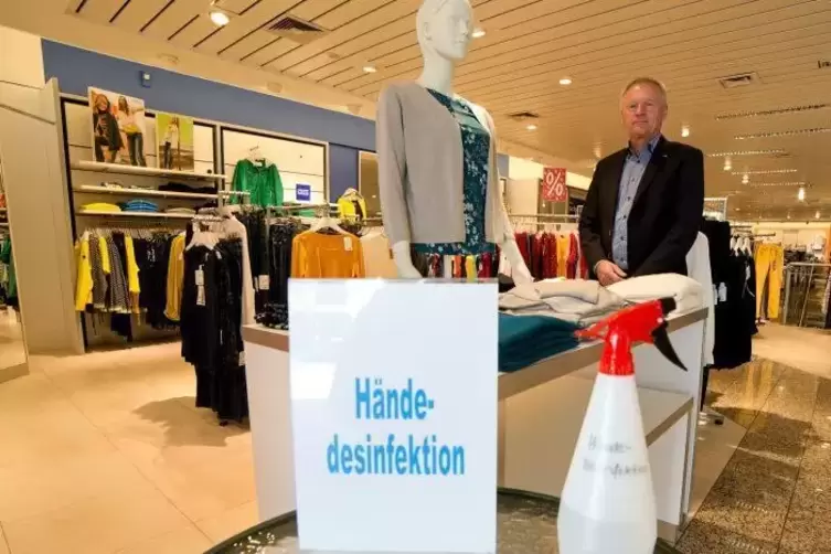 Auch beim Modehaus Bischoff (hinten Inhaber Michael Bischoff) steht H&auml;ndedesinfektion bereit.