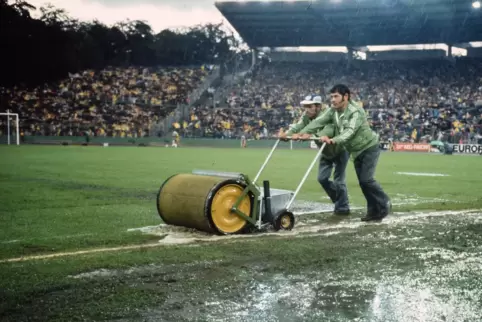 Verzweifelt: Helfer versuchen, bei der WM 1974 die Wassermassen vom Rasen zu walzen. 