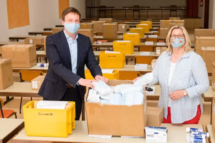Ministerpräsident Tobias Hans und Wirtschaftsministerin Anke Rehlinger posieren mit Masken, die das Saarland vor Corona schützen