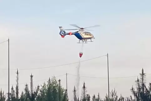 Hubschrauber der Polizei mit Löschsack bei Brand in Enkenbach bei Munitionsdepot.