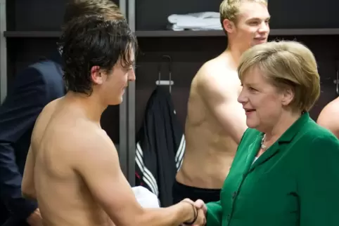 Angela Merkels Besuch in der Kabine der deutschen Nationalmannschaft 2010, hier mit Mesut Özil, nähren die Hoffnungen vieler, da
