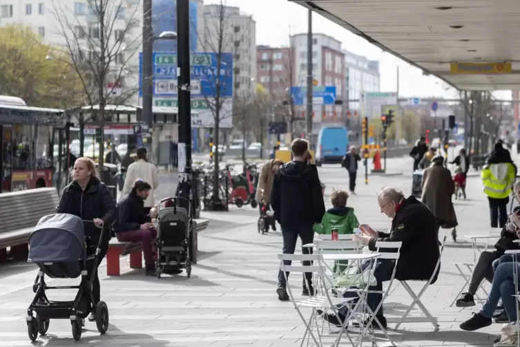 Stockholm: Die Menschen sitzen im Stadtzentrum vor einem Eiscafe. 