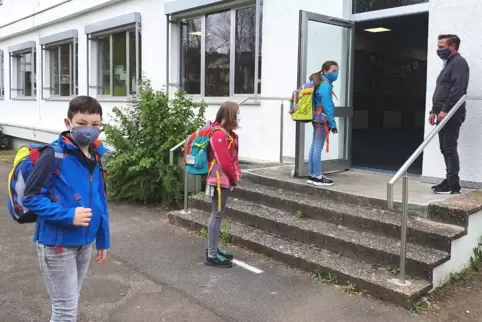 In die Schule stürmen? In Zeiten der Corona-Pandemie geht das nicht. Schulleiter Sascha Hinkel (rechts) nimmt Ben, Yasmin und Em