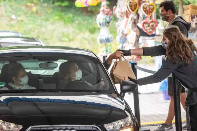 G&auml;ste holen in einem Drive-in-Festzelt mit ihren Autos Essen ab. 