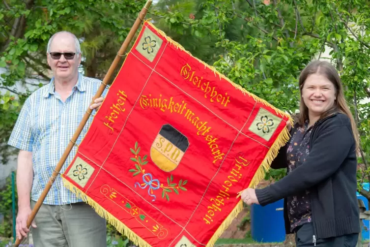 SPD-Vorsitzender Volker Ullmer und Ratsmitglied Christine Sawitzki zeigen die dekorativ bestickte Vereinsfahne. Sie stammt aus d