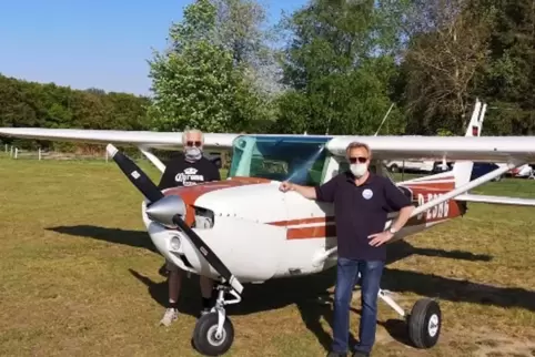 Mit Maske: Der Vorsitzende des Flugsportvereins Kusel-Langenbach, Gerd Rudolph (rechts), und Roland Sauer an ihrer Cessna 150.